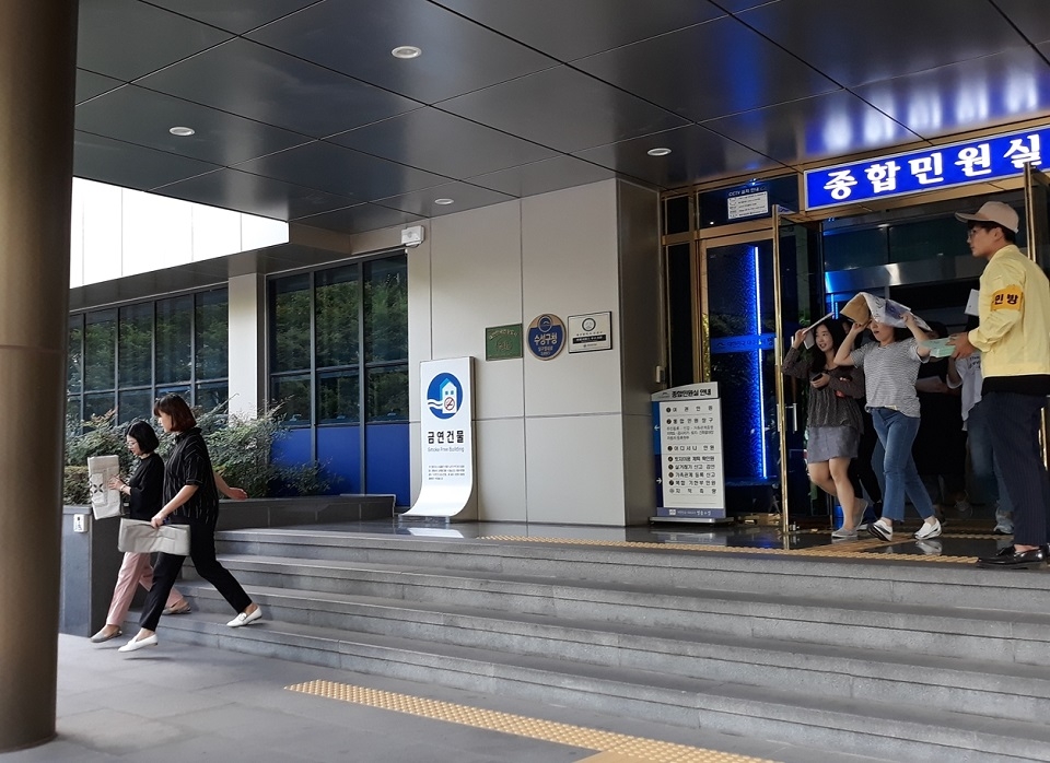 수성구청 직원들이 지진을 가정한 대피훈련에서 머리를 보호한 채 건물을 빠져 나오고 있다.