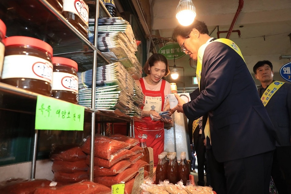 김대권 수성수청장이 목련시장에서 온누리상품권으로 물건을 구입하고 있다.