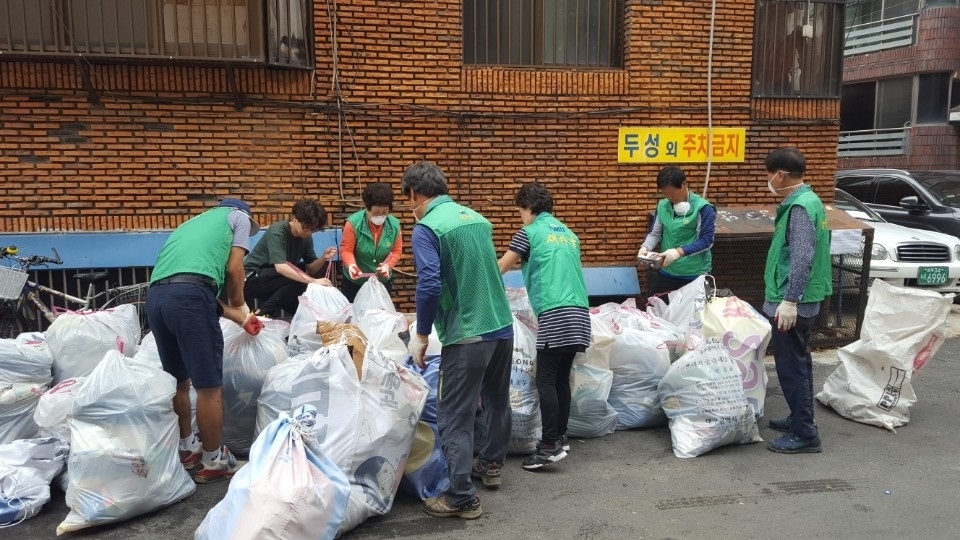 수성1가동 협력단체 회원들이 침수된 지하주택의 쓰레기를 치우고 있다.