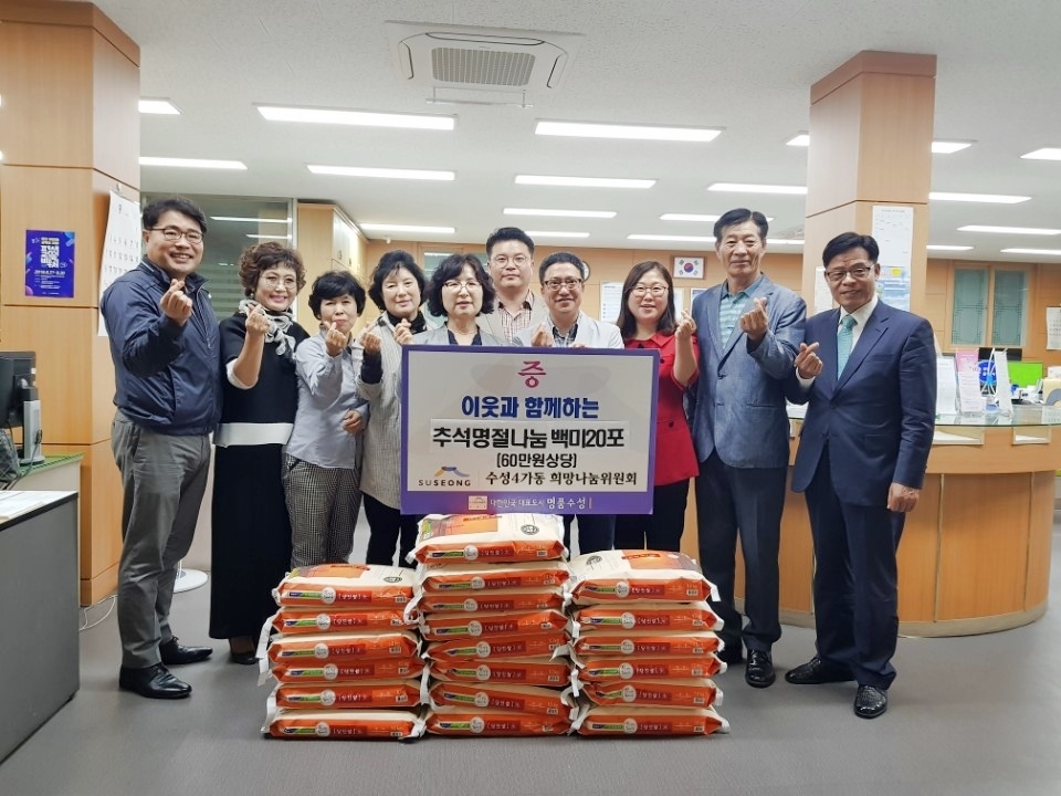 수성4가동 희망나눔위원회 회원들이 백미를 전달하고 기념촬영을 하고 있다.