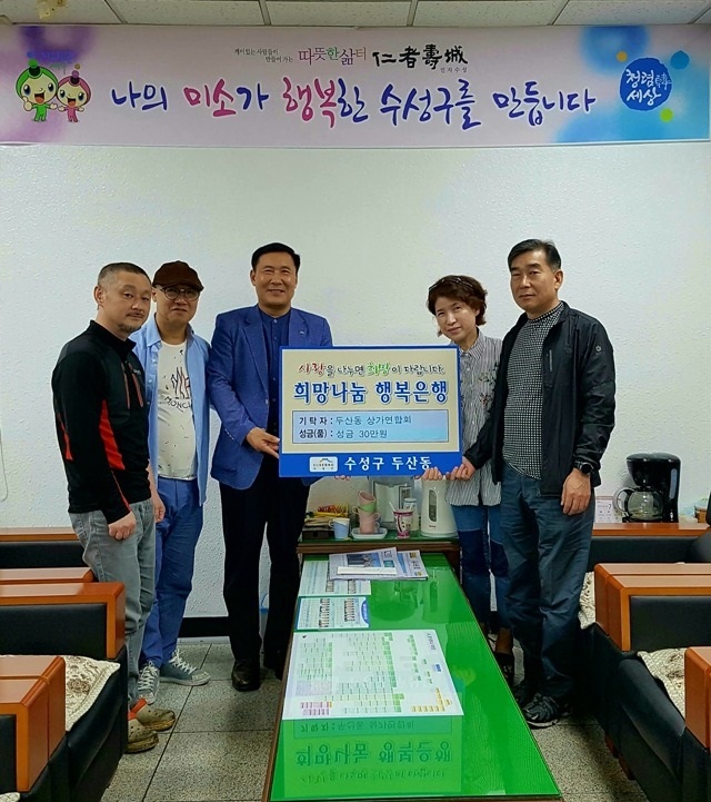 두산동 상가연합회 회원들이 성금을 전달하고 기념촬영을 하고 있다.      (왼쪽부터 세 번째 최준호 두산동장, 네 번째 박은경 상가연합회 회장)